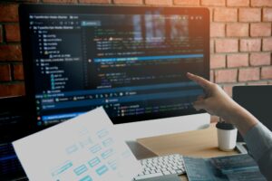 Man hands pointing coding html and programming develop on screen computer.