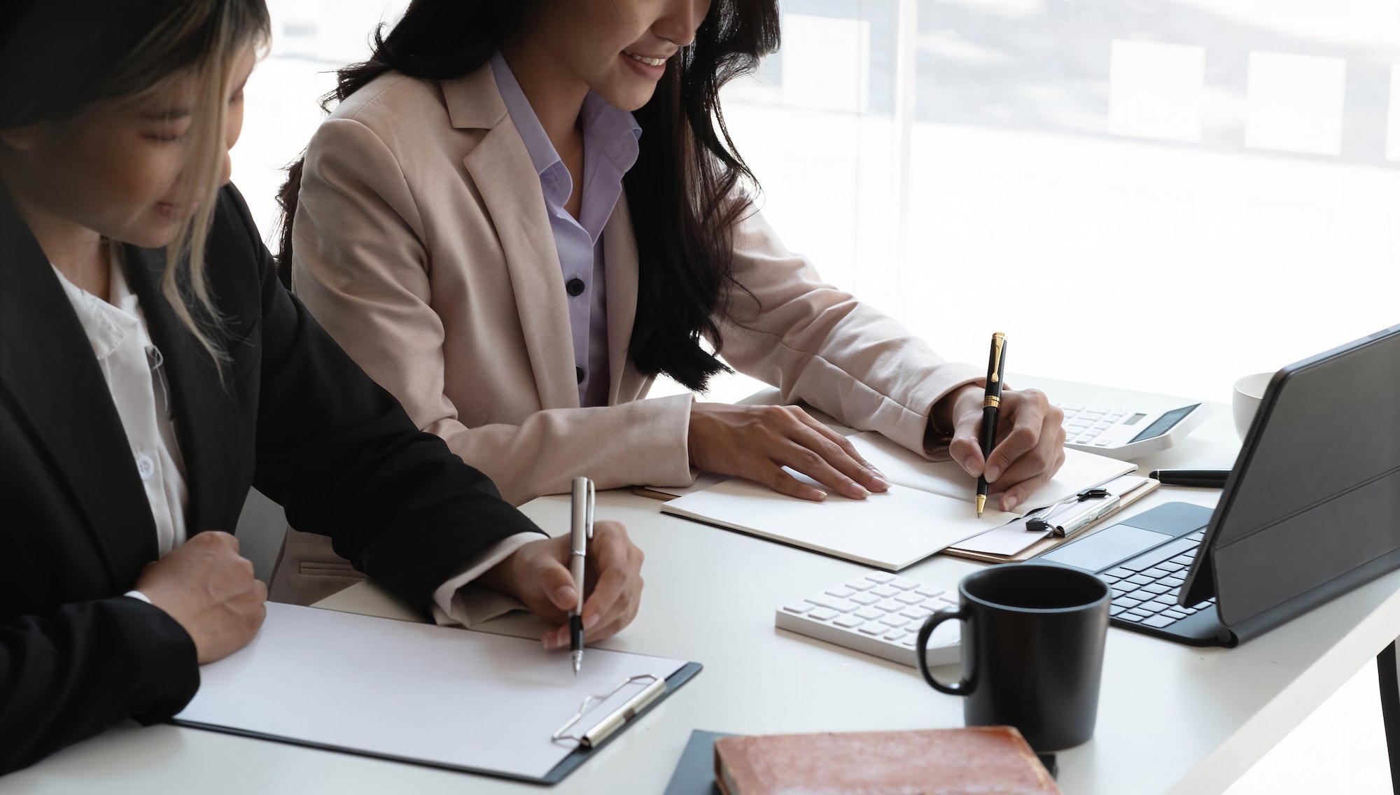 Young Asian businesswoman work together to analysis from work at the office.