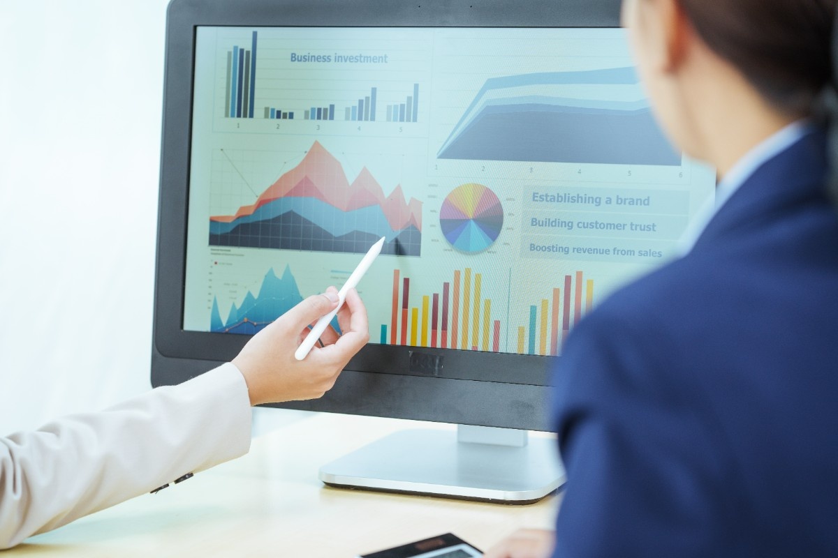 Professional reviewing business analytics dashboard with multiple metrics and performance indicators