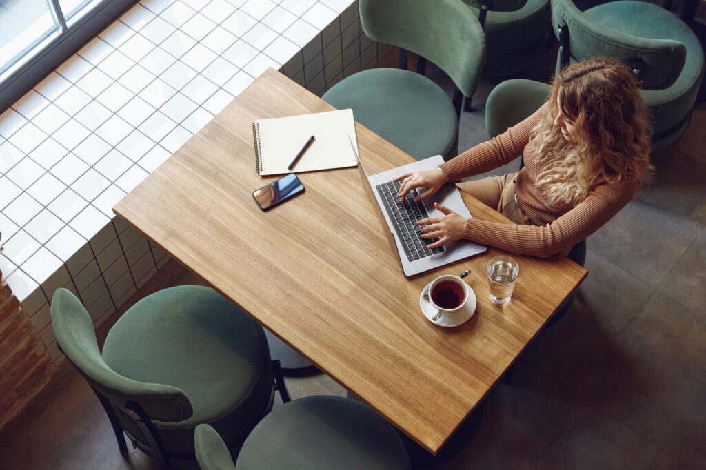 Busy woman sitting at table and using laptop