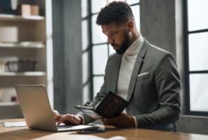 Young african american businessman working on laptop indoors in office
